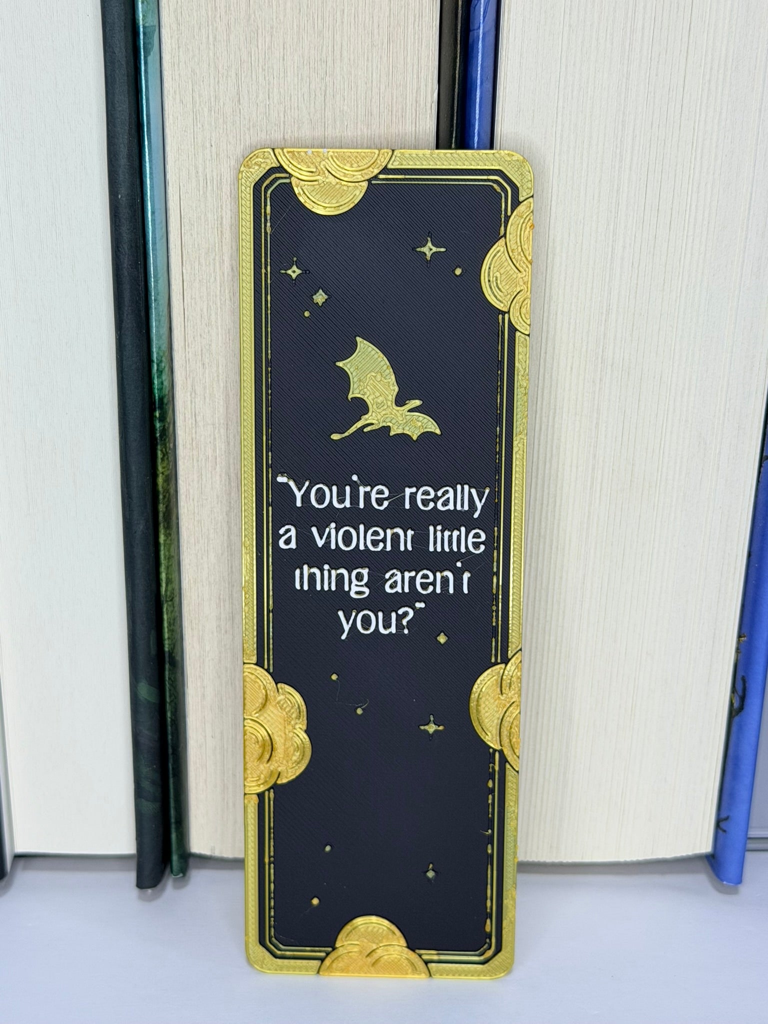 Bookmark with gold accents and text on a book