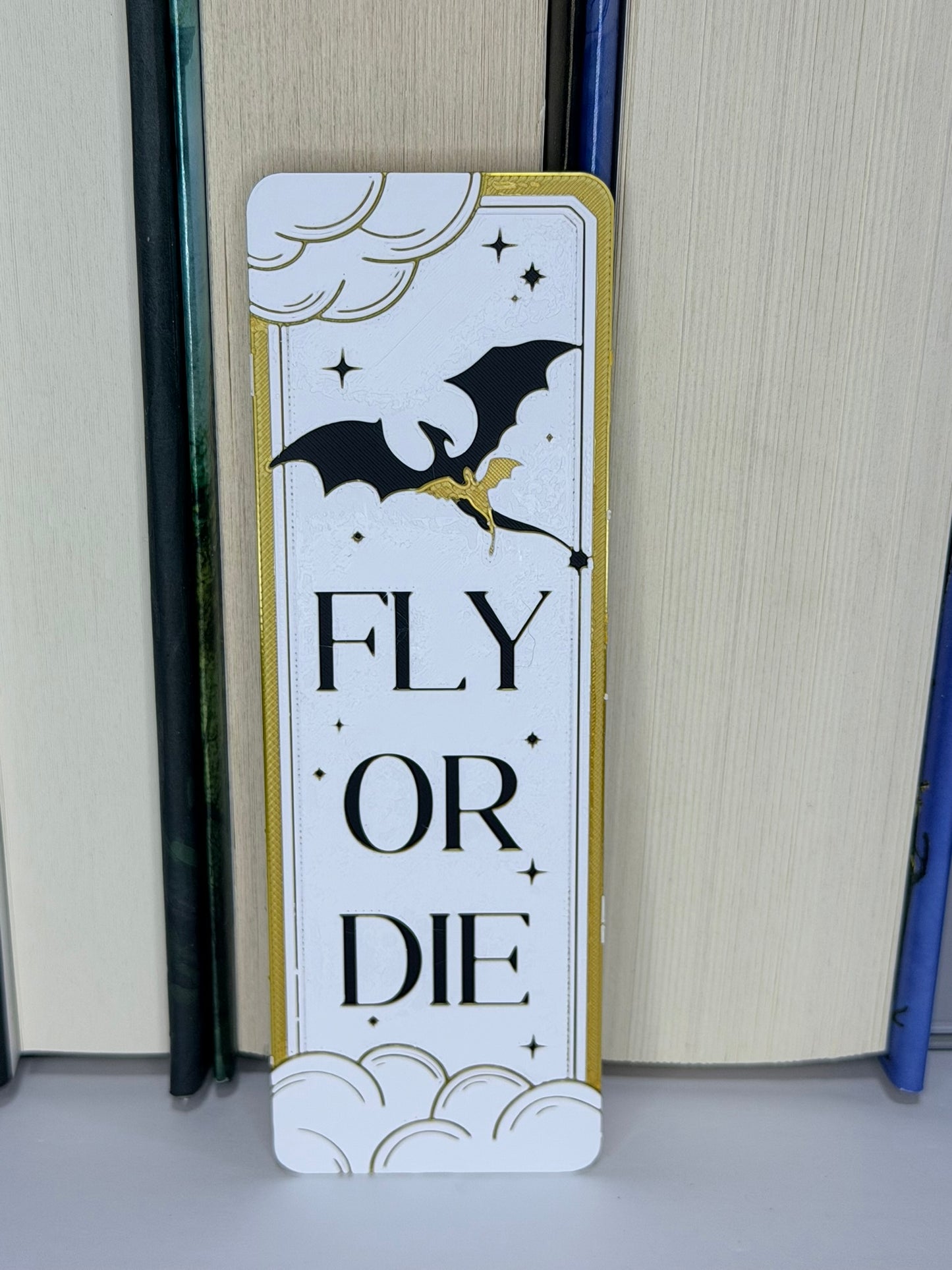 Decorative bookmark with bat and dragon design and 'Fly or Die' text on a plain background.