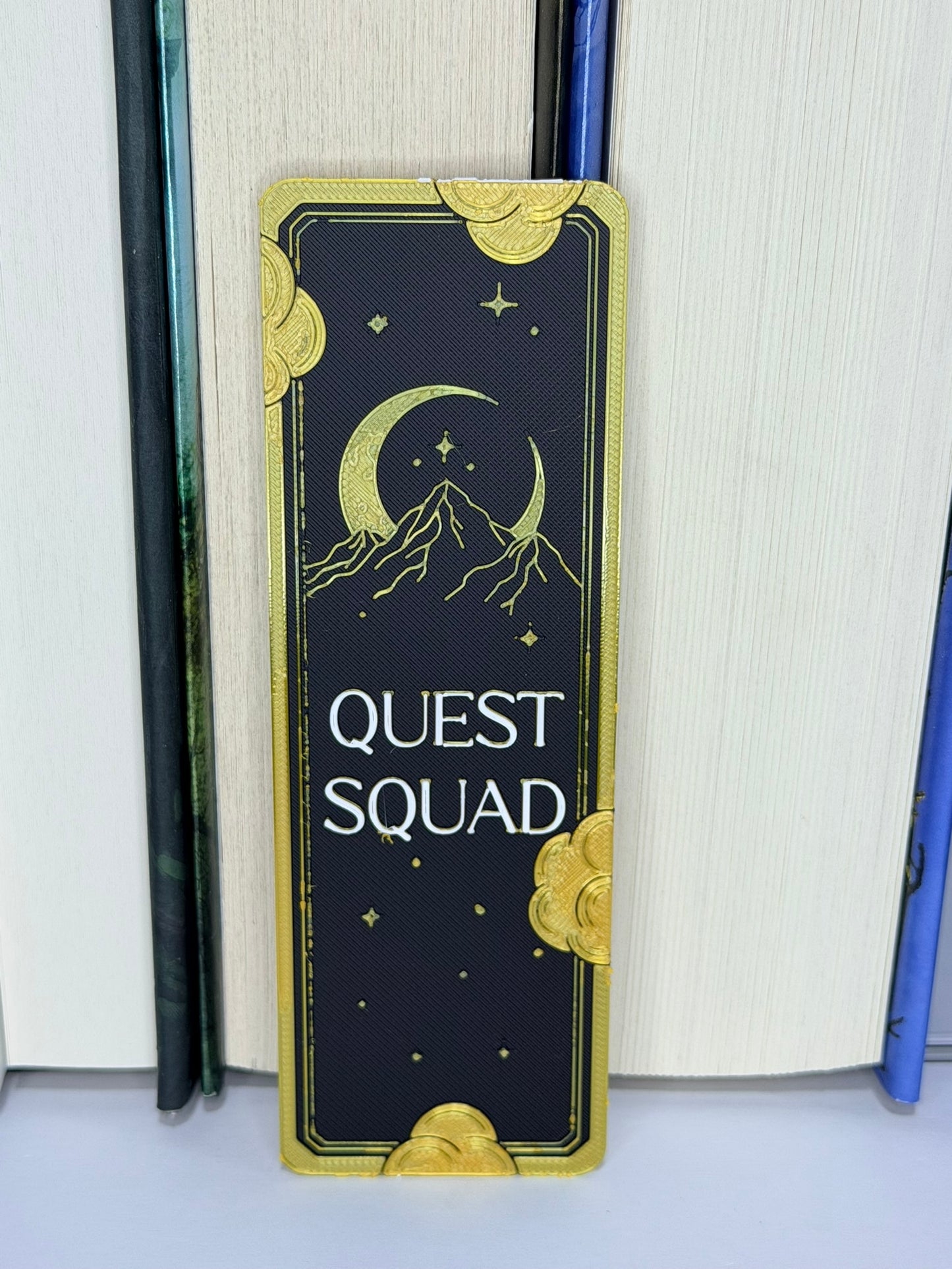 Bookend with 'Quest Squad' design on a white surface