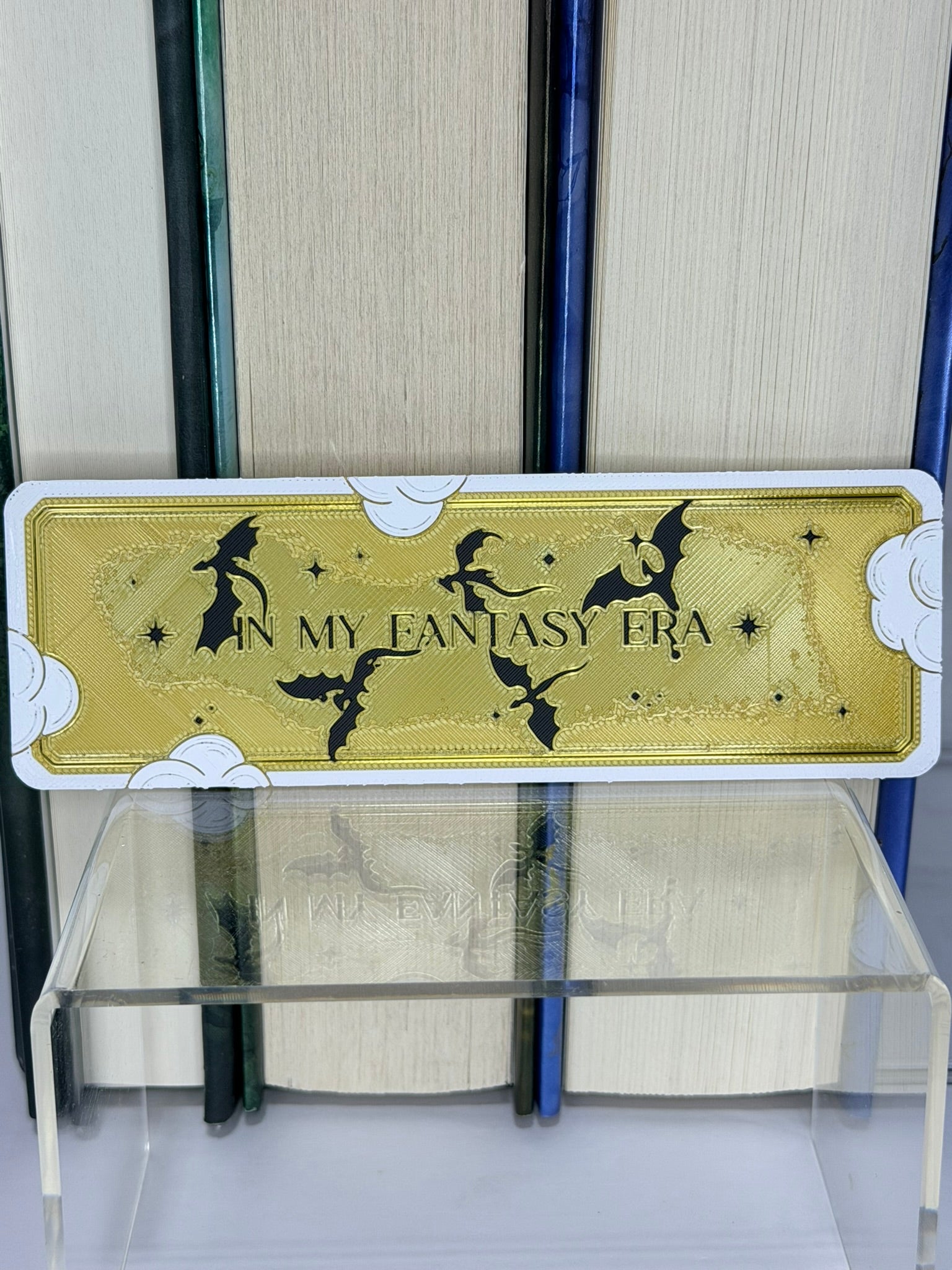 Bookmark with 'In My Fantasy Era' text and silhouette designs on a bookshelf.